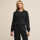 Woman wearing Z Supply All Around Sweatshirt in Black on a beige background