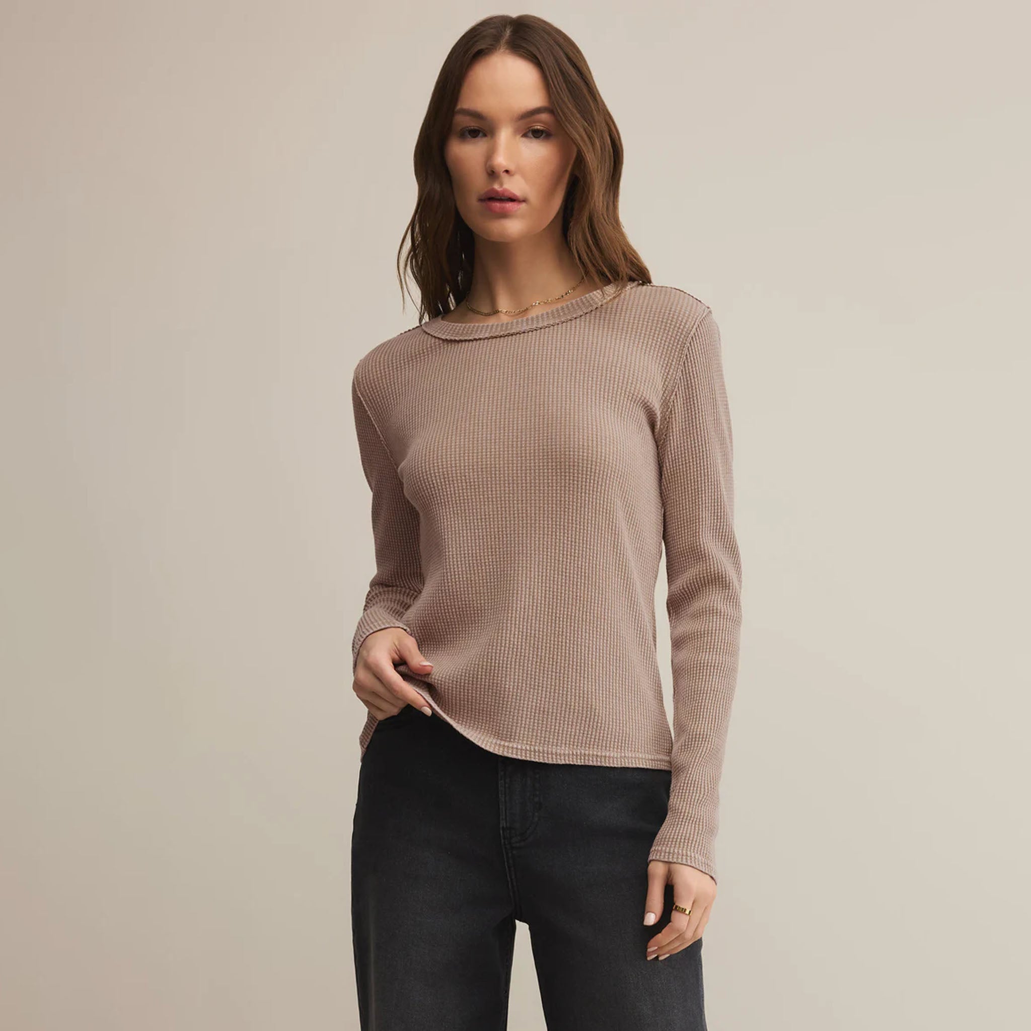 Woman wearing Z Supply Arlet Thermal Top Jet in Desert Tan and black pants against a plain background