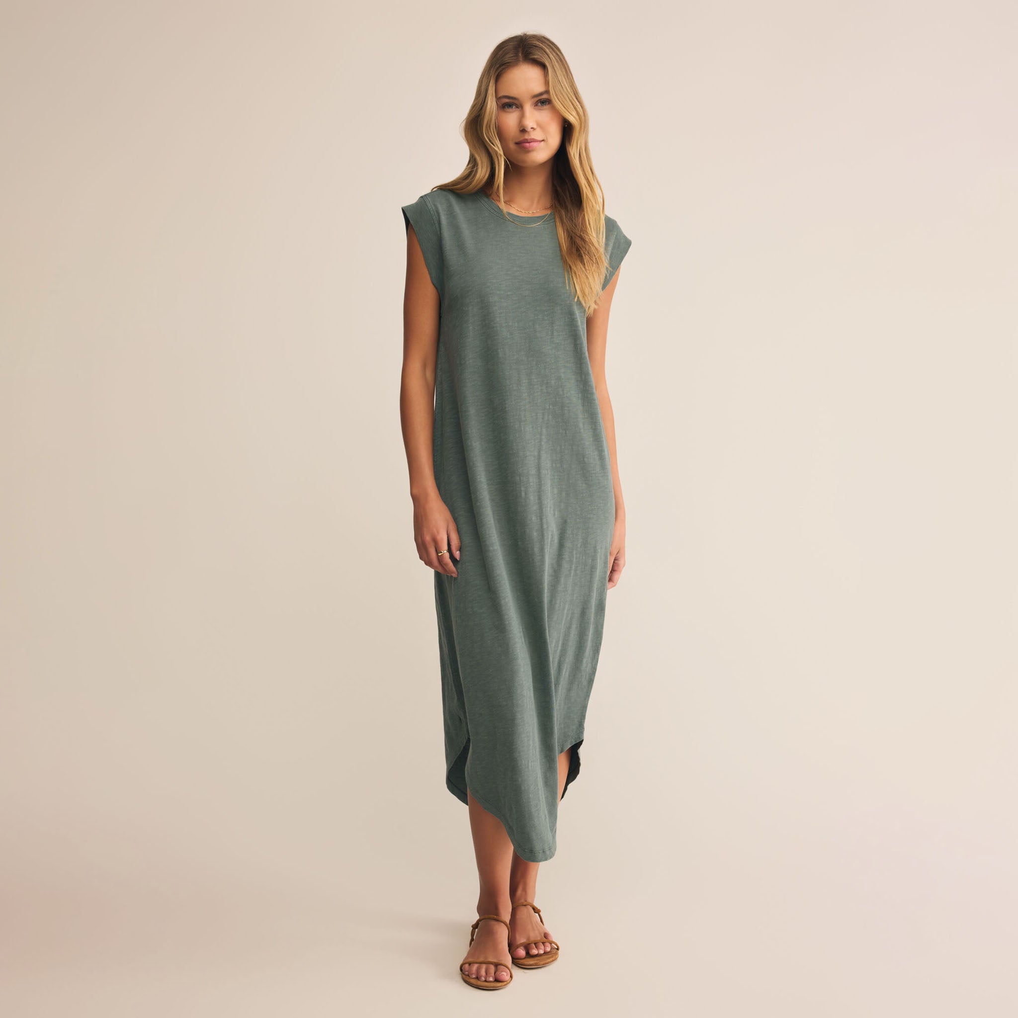 Woman wearing a green dress against a beige background