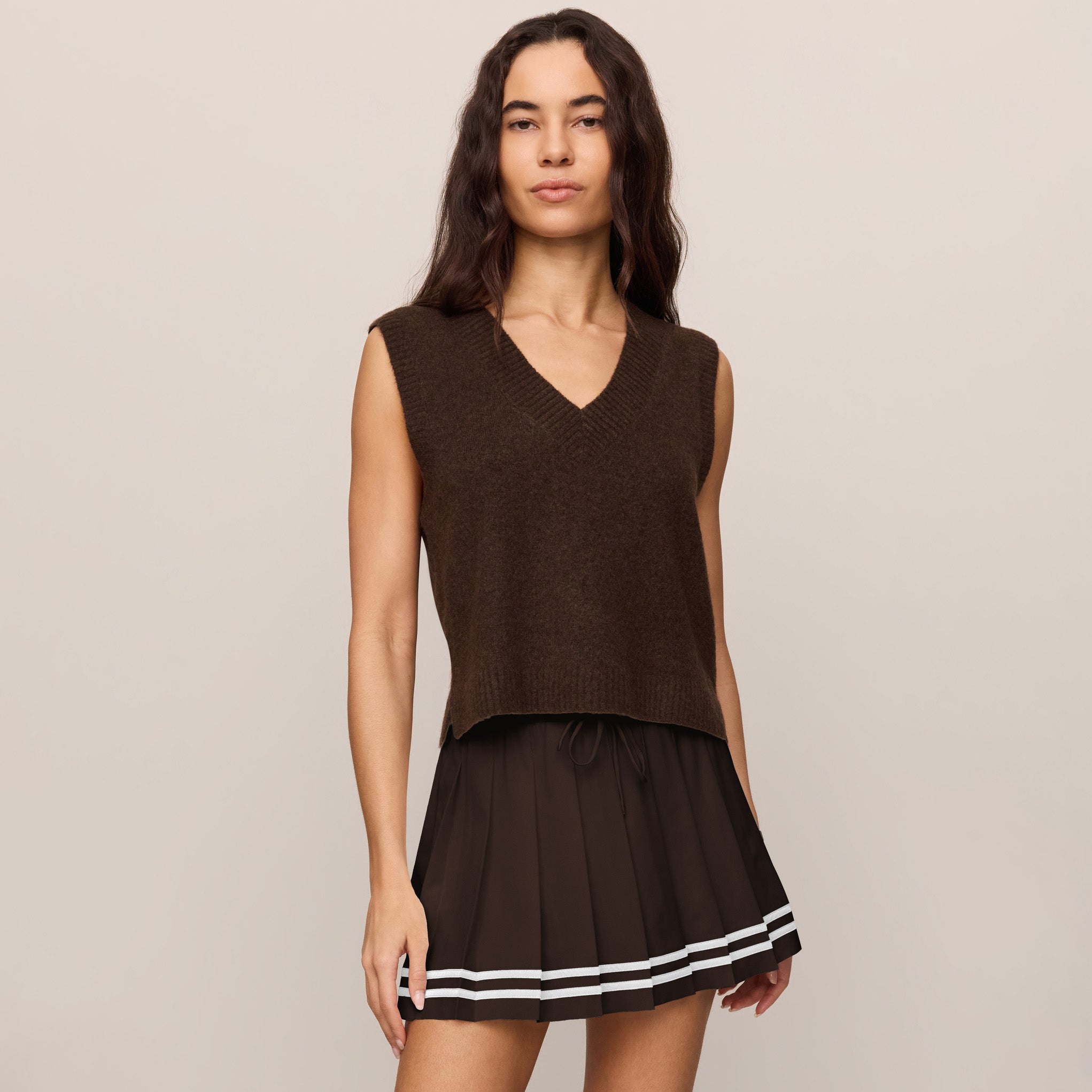 Woman wearing Z Supply Classic Act Sweater Vest in Dark Chocolate on plain background at Addison West.