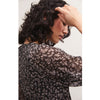 Brunette model wearing Z Supply Della Floral Midi Dress in Black with black boots in front of a white background