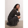 Brunette model wearing Z Supply Della Floral Midi Dress in Black with black boots in front of a white background