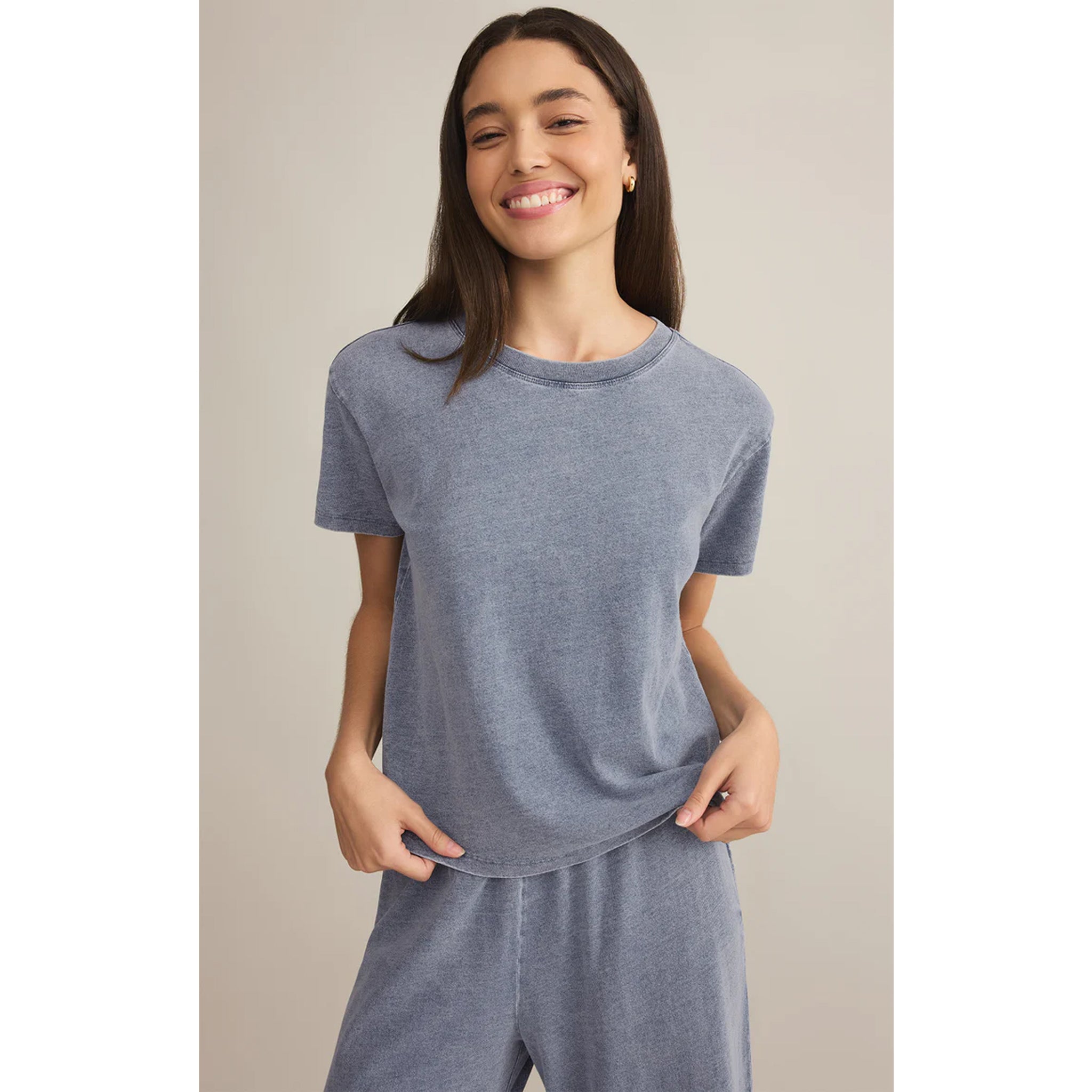 Model wearing Z Supply Go To Denim Tee in Medium Indigo with matching pants in front of a neutral backdrop
