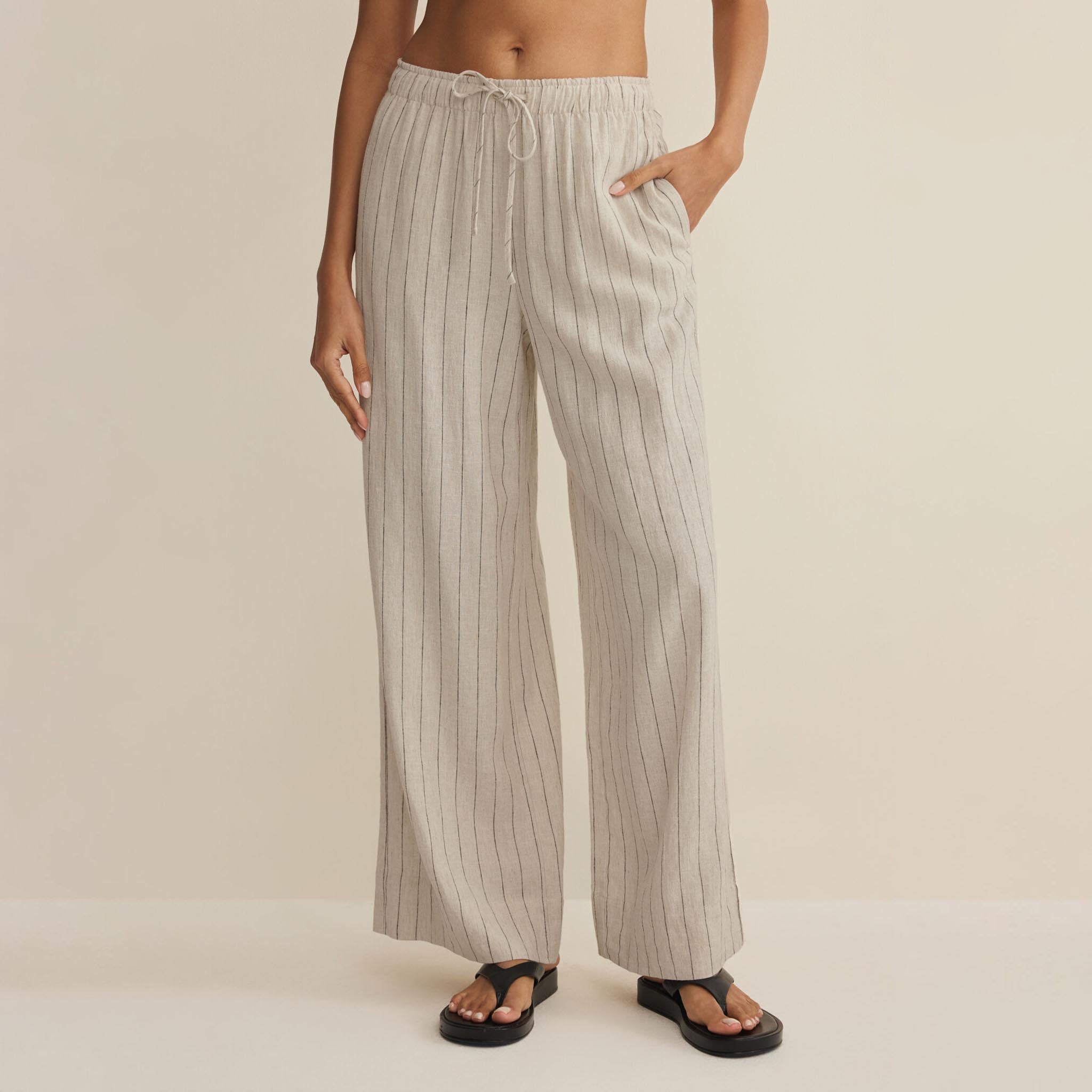 Person wearing striped pants on a beige background