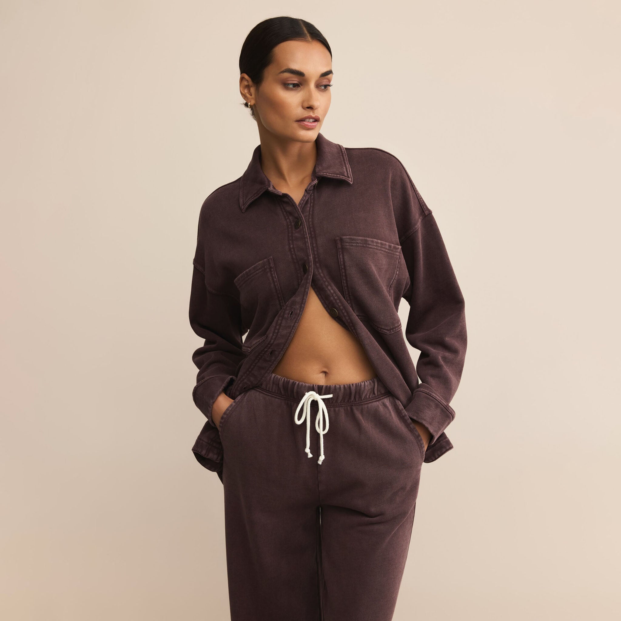 Woman wearing Z Supply Hunter Knit Denim Pant in Chocolate Cherry with matching top against a neutral background