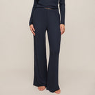Navy blue pants worn by a person on a beige background