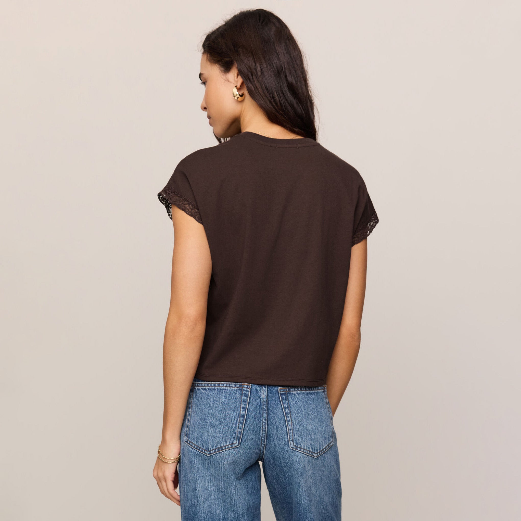 Woman wearing Z Supply Markia Lace Trim Muscle Tee in Dark Chocolate on plain background at Addison West.