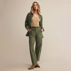 Woman wearing Z Supply Olive Twill Pants in Hunter Green with a beige top against a plain background