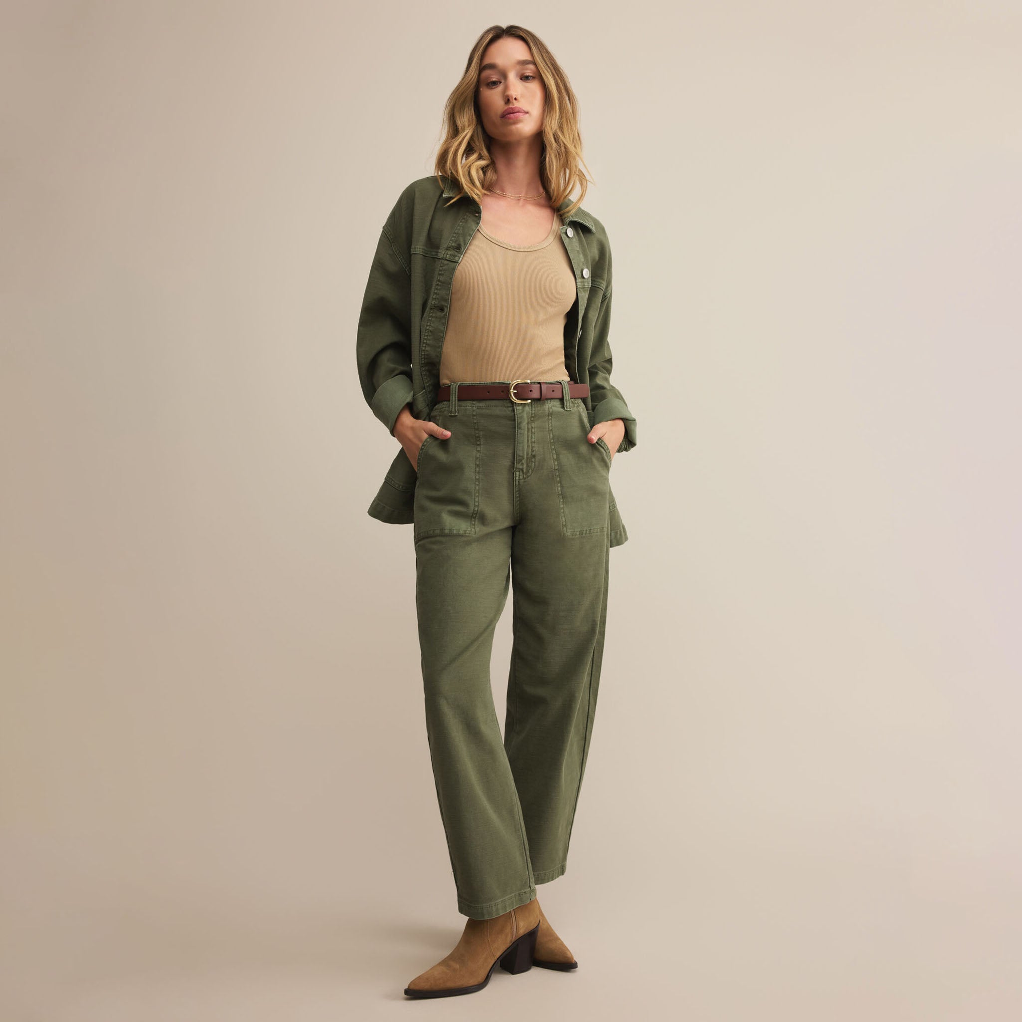 Woman wearing Z Supply Olive Twill Pants in Hunter Green with a beige top against a plain background