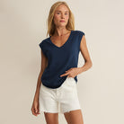 Woman wearing Z Supply Per Diem V-Neck Tank in Eclipse on plain background at Addison West.