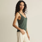 Woman wearing Z Supply Perch Sweater Tank in Everglade on plain background at Addison West.