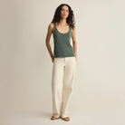 Woman wearing Z Supply Perch Sweater Tank in Everglade on plain background at Addison West.