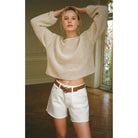 Model wearing Z Supply Riviera Crochet Top in Natural with white jean shorts in a room with wood floors