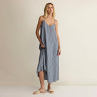 Woman wearing a blue striped dress on a beige background