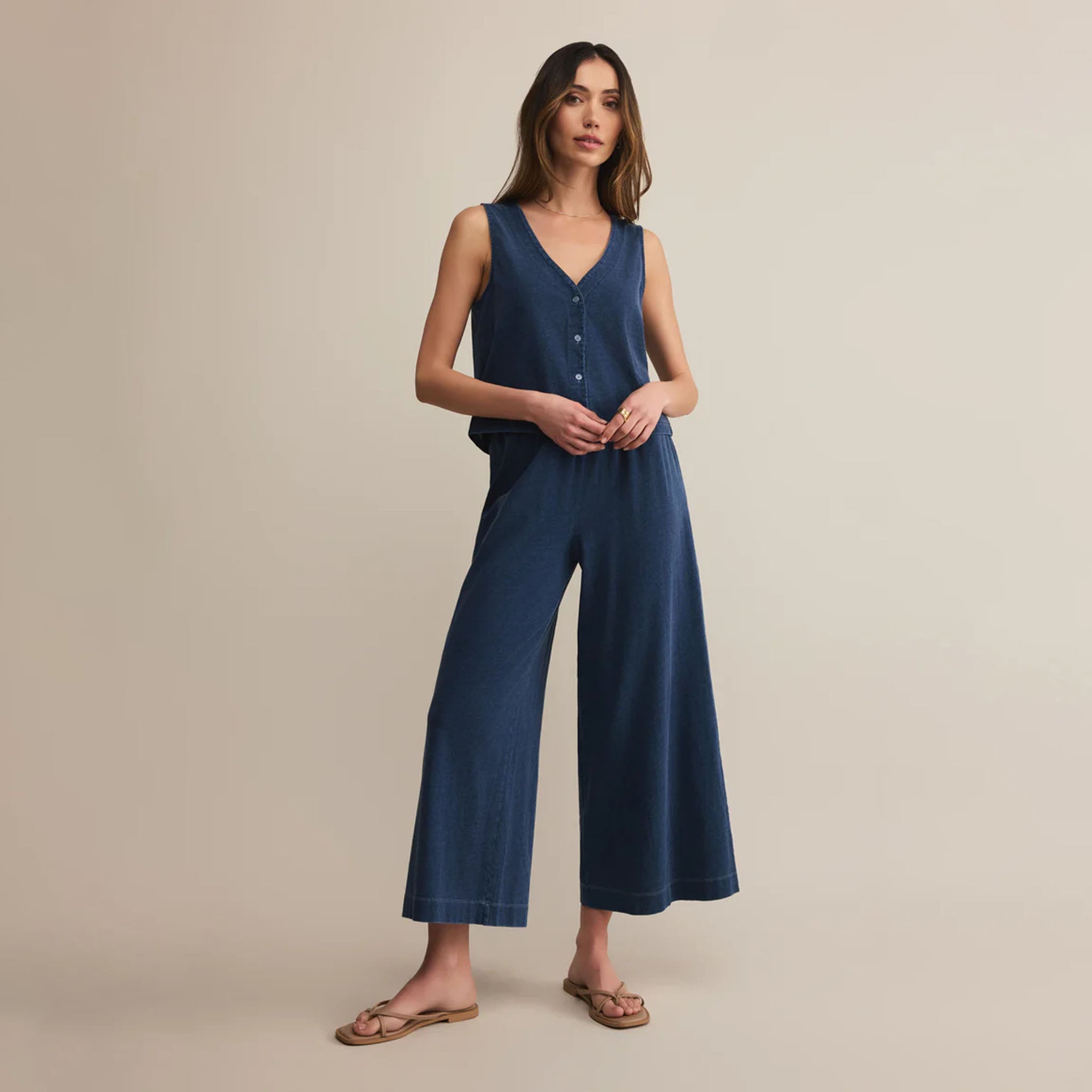 Woman wearing Z Supply Scout Jersey Denim Pant in Indigo on a beige background