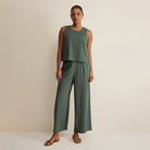 Woman wearing Z Supply Scout Linen Pants in Everglade on plain background at Addison West.
