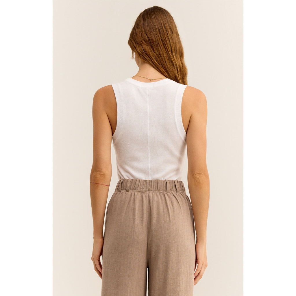 View from back of Model wearing Z Supply Sirena Rib Tank in White with beige pleated linen pants