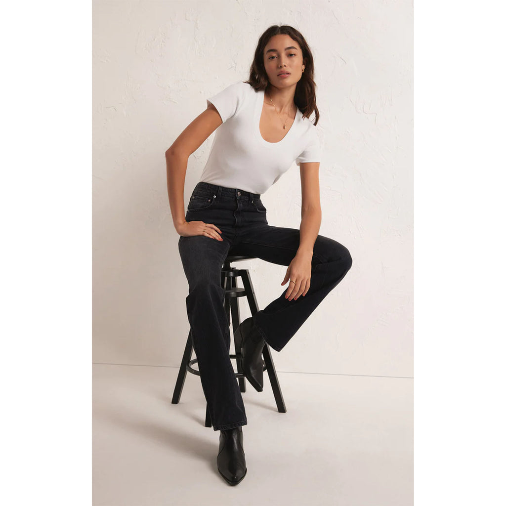 Model wearing Z Supply Sirena Short Sleeve Tee in White with black jeans sitting on a stool