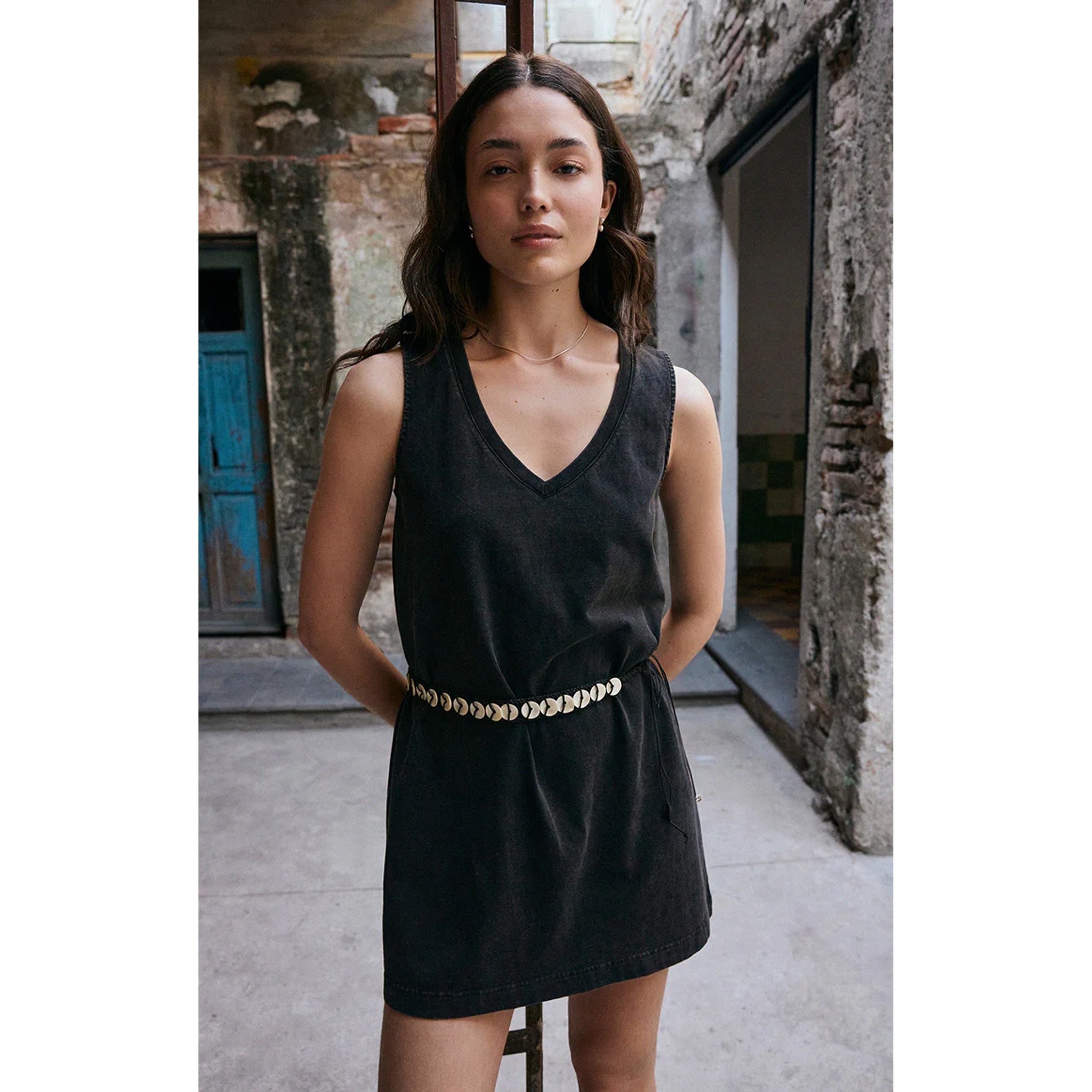 Model wearing Z Supply Sloane V-Neck Mini Dress in Black in front of a stone building