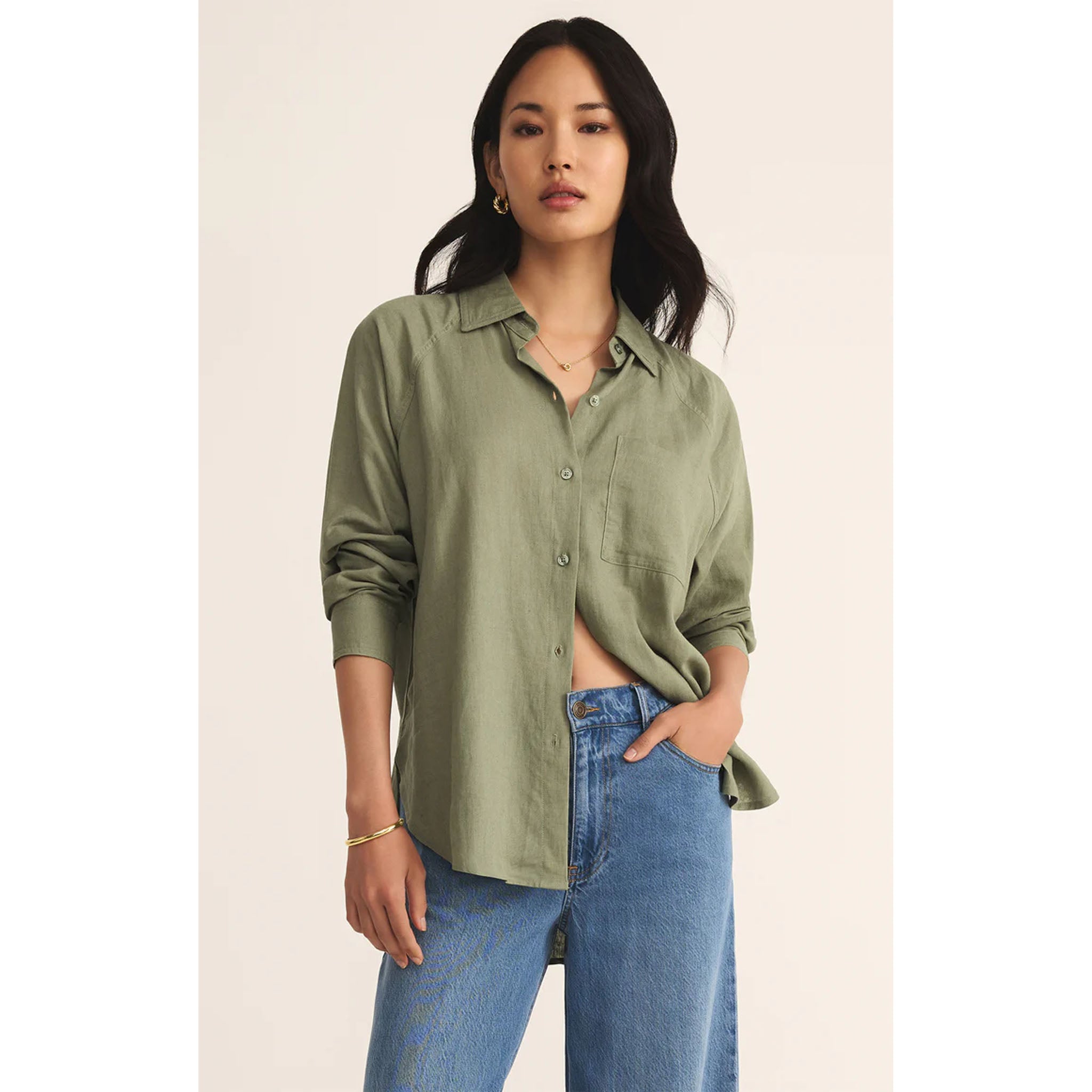 Model wearing Z Supply The Perfect Linen Top in Avocado with jeans in front of a neutral backdrop