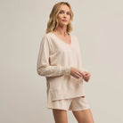 Woman wearing Z Supply Weekender V Neck in Light Oatmeal Heather on a plain background