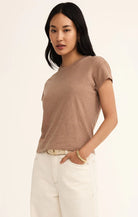Model wearing Z Supply Modern Slub Tee in Iced Coffee with light pants in front of a neutral background