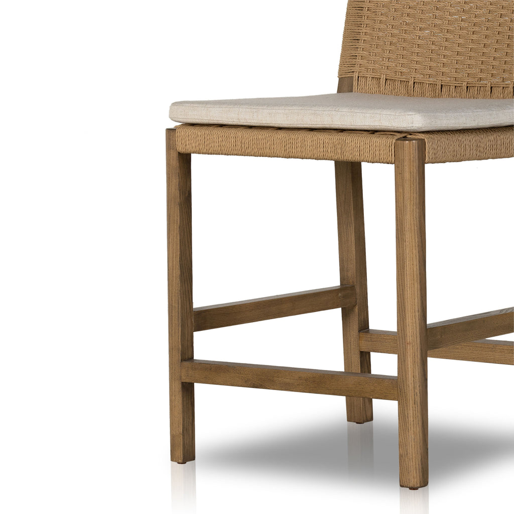Four Hands Zuma counter stool with beige cushion and woven back in Dune Ash on a white background