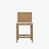 Four Hands Zuma counter stool with beige cushion and woven back in Dune Ash on a white background
