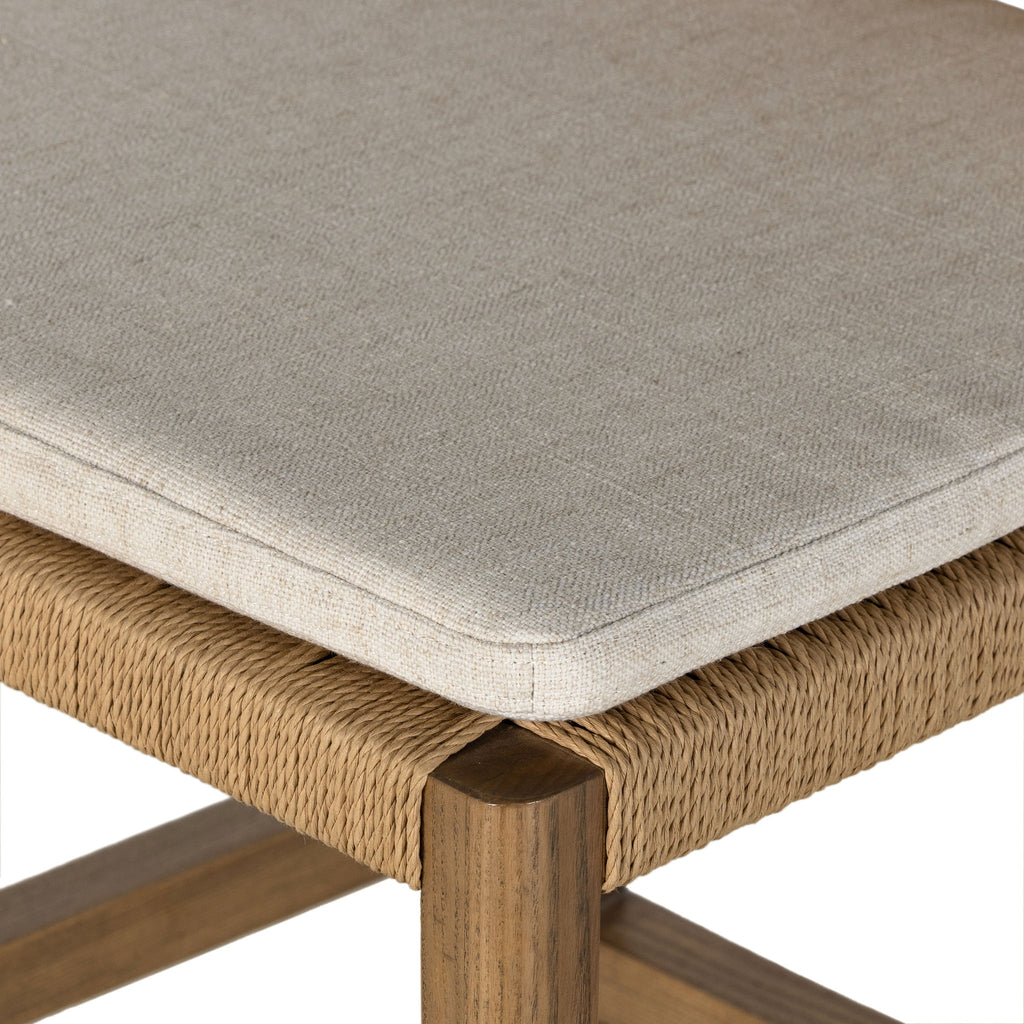 Four Hands Zuma counter stool with beige cushion and woven back in Dune Ash on a white background