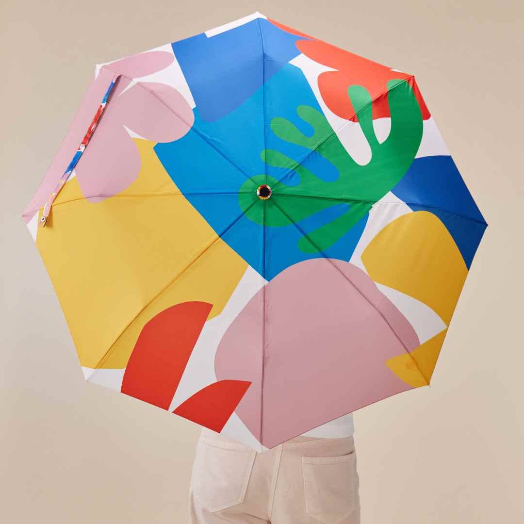 Person holding Original Duckhead Matisse Eco-Friendly Umbrella on a beige  background at Addison West