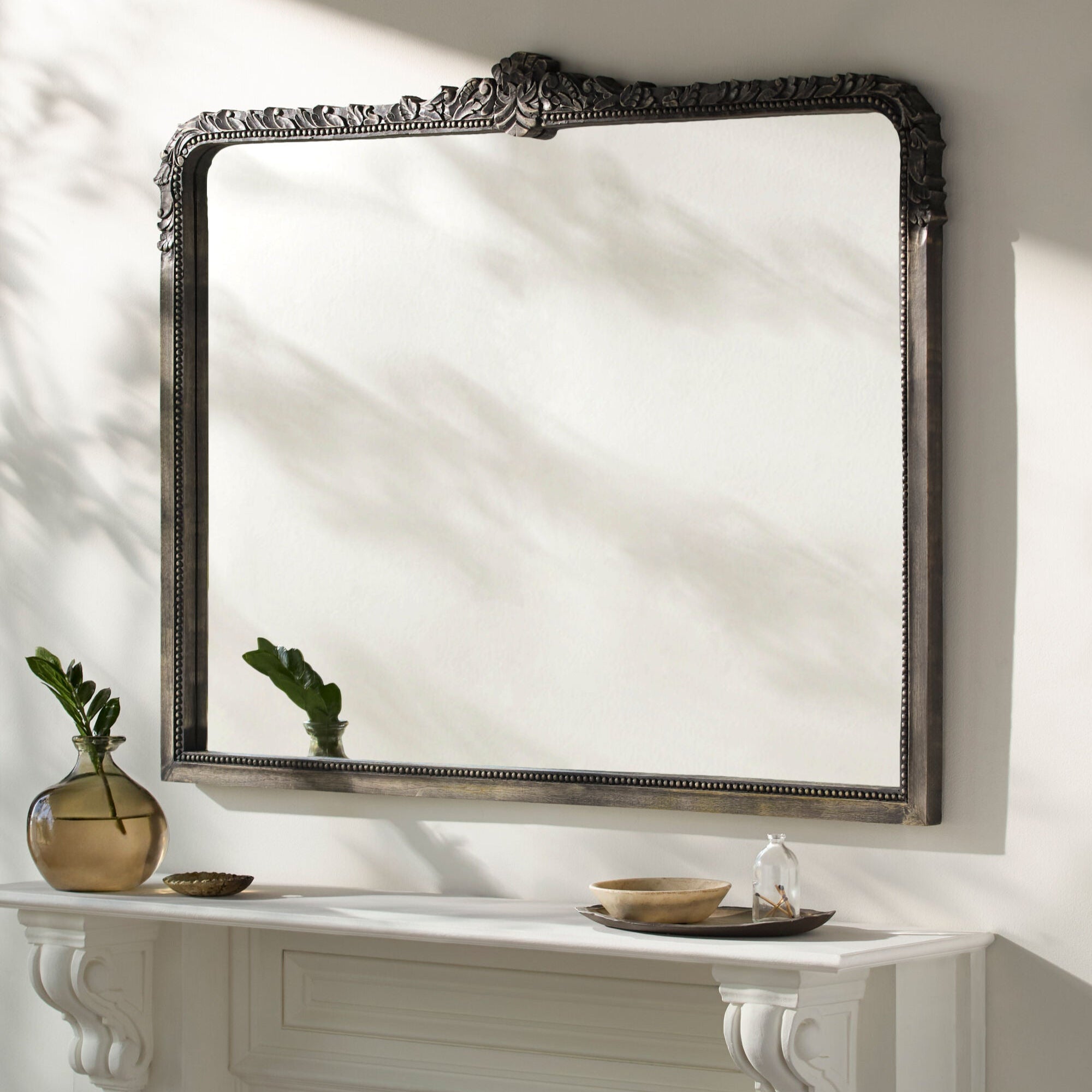 Aaliyah Mantel Mirror in Natural Black on a white wall at Addison West