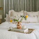 Heirloom Copper Syrup Pourer used as a vase on a tray on a bed with flowers in it at Addison West