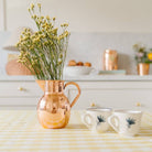Heirloom Copper Syrup Pourer used as a vase on kitchen counter with flowers in it at Addison West