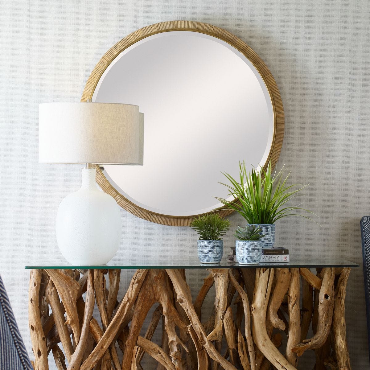 Parnell Round Accent Mirror on a beige wall above a table at Addison West