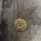 Tiny Anvil Brass Vault Necklace on a grey background at Addison West