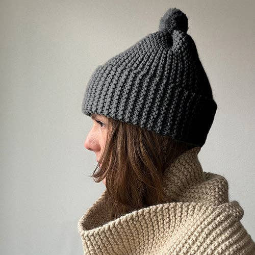 Knitting Craft Kit: Classic Pom Beanie in Medium Grey on a beige background at Addison West