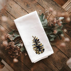 Pinecone Tea Towel on a wood table at Addison West