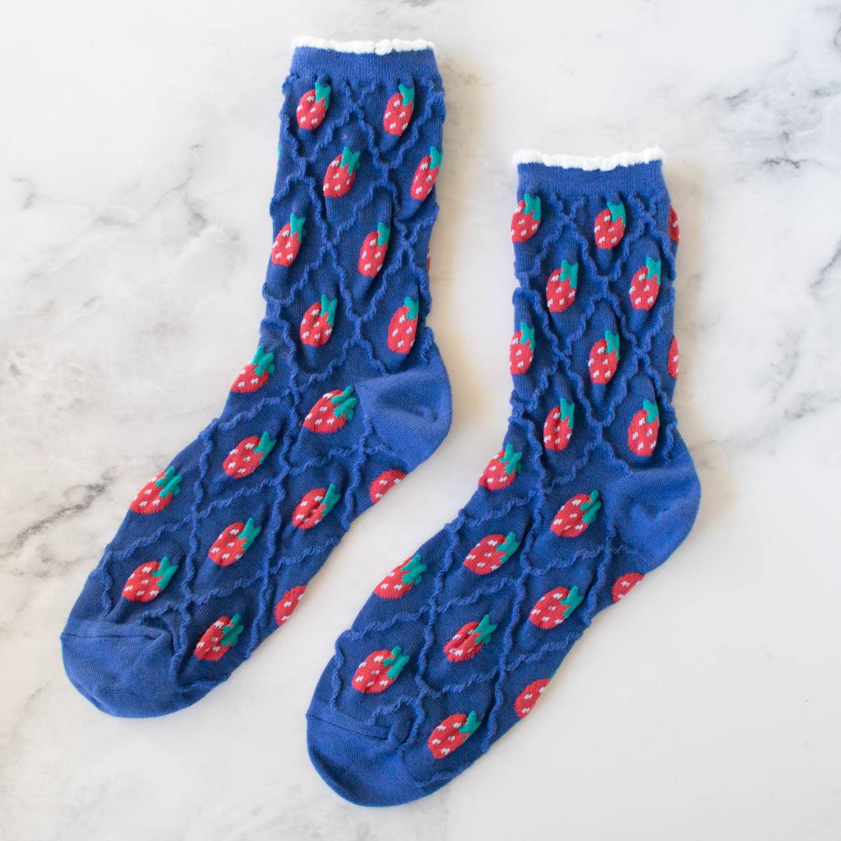Retro Strawberry Socks in Blue on a table at Addison West