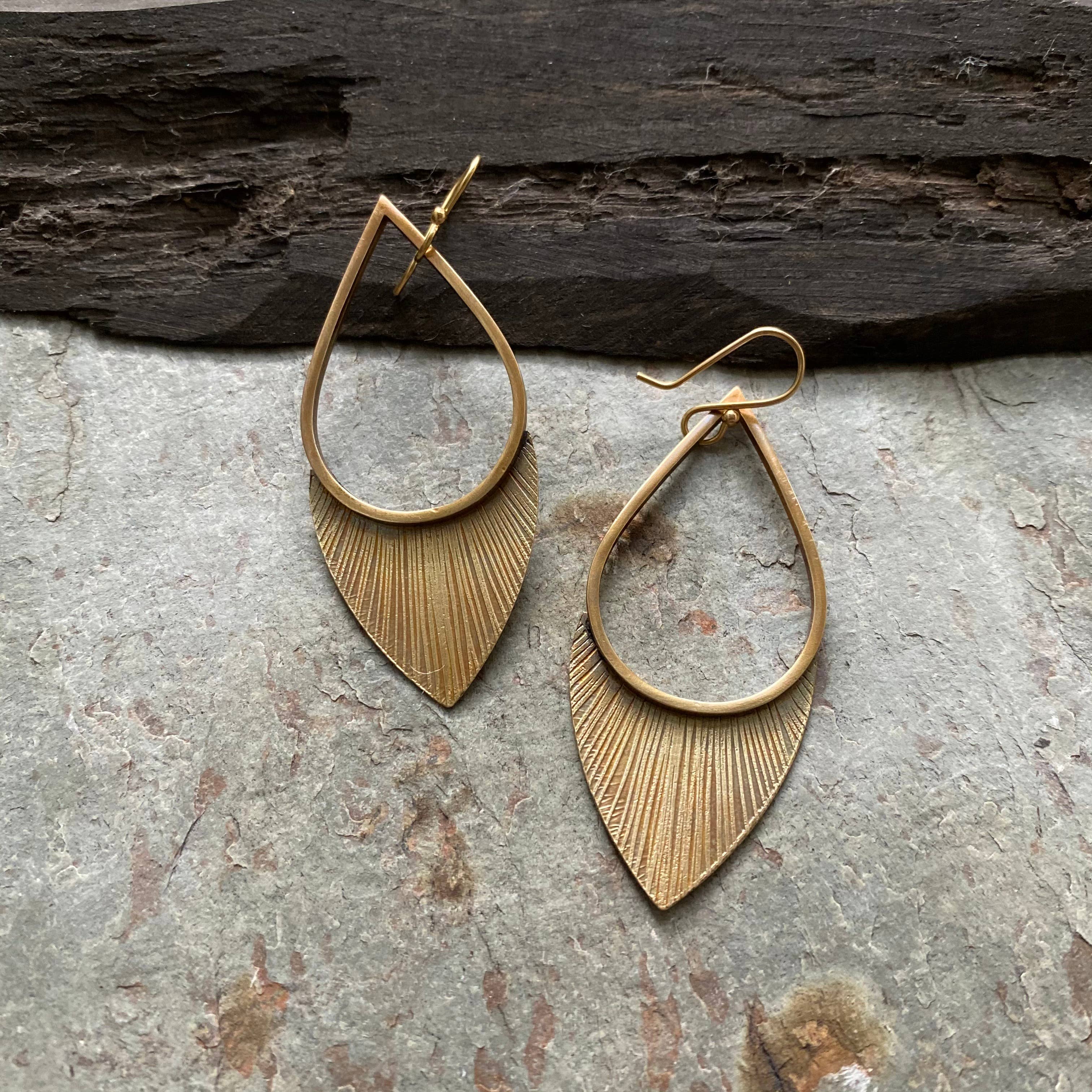 Tiny Anvil Brass Flora Earrings on a grey background at Addison West