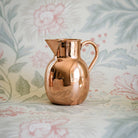 Heirloom Copper Syrup Pourer on a floral background at Addison West