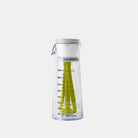 Clear measuring cup with green mixer on a white background