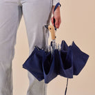 Person holding Original Duckhead Navy Eco-Friendly Umbrella on a beige background at Addison West