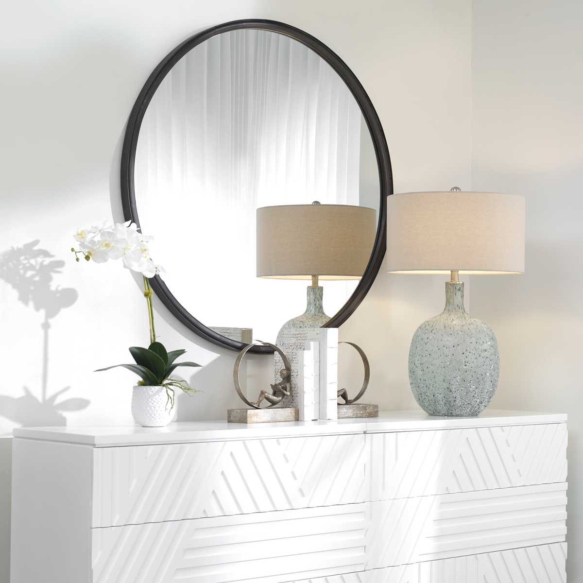 Dawsyn Round Mirror on a white wall above a table at Addison West