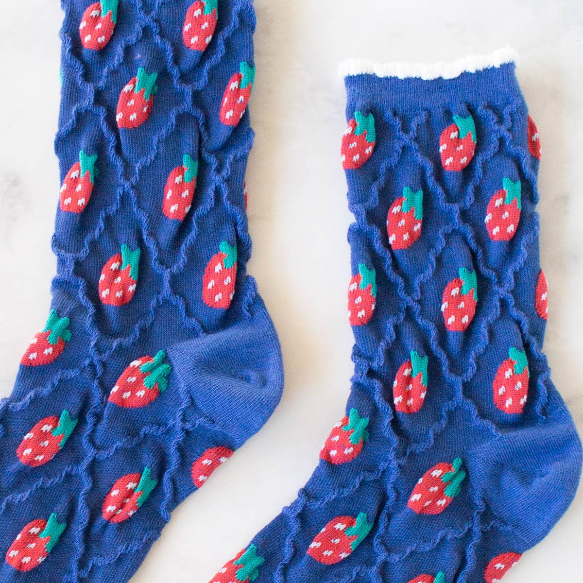 Retro Strawberry Socks in Blue on a table at Addison West