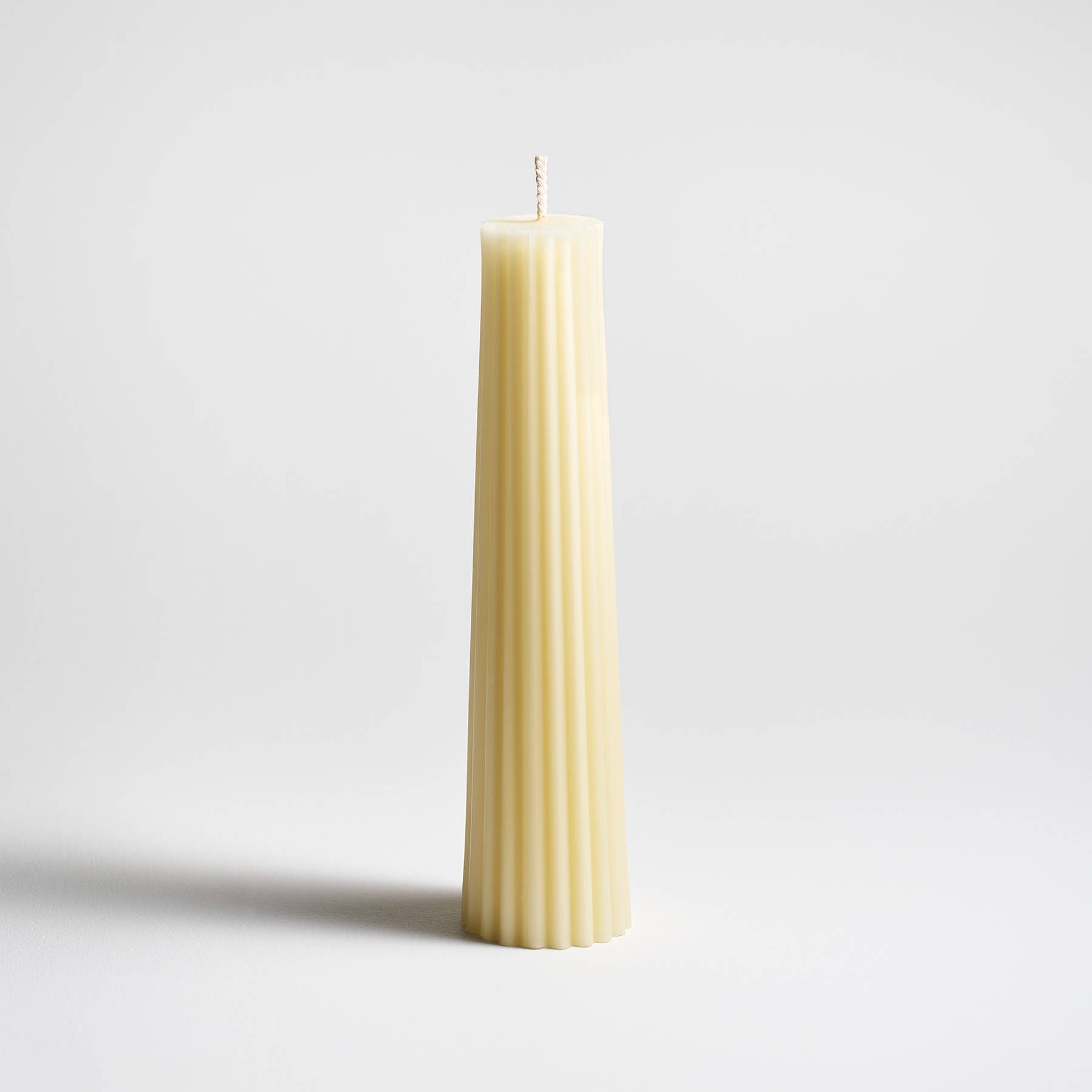 Greentree 8" Petite Pillar Candle in Cream on a white background at Addison West