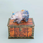 Decorative bear figurine cake topper on a wooden chest with a light blue background