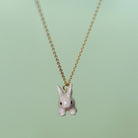 Camp Hollow Porcelain Goldentail Rabbit Necklace on green background.