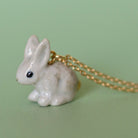 Camp Hollow Porcelain Goldentail Rabbit Necklace on green background.