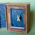 Camp Hollow Porcelain Goldentail Rabbit Necklace in box on green background.