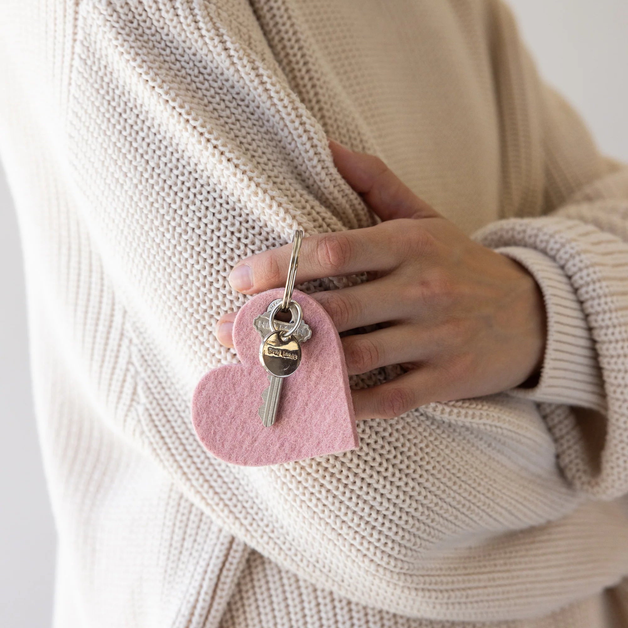 Graf Lantz Merino Wool Heart Key Fob in Rock Salt on a white background with a model at Addison West